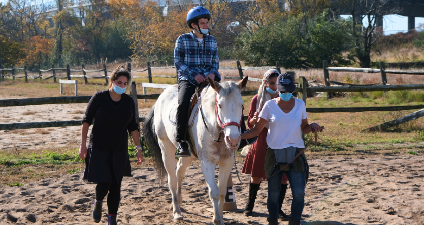 Person riding a horse on a scenic trail, showcasing a peaceful outdoor experience and connection with nature.